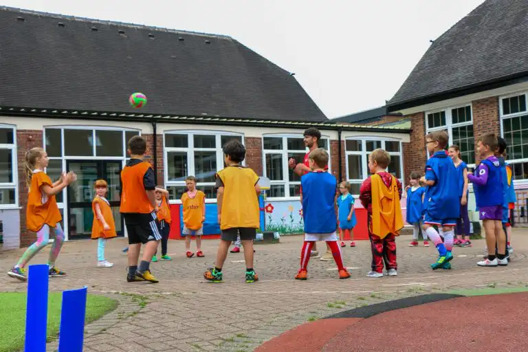 Group of Time4Sport kids camp children playing a ball game