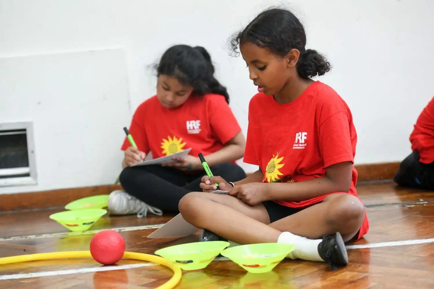 Child sitting on the floor writing on paper