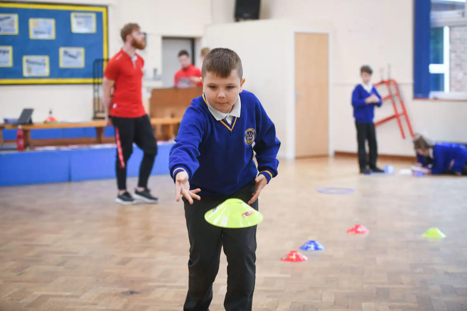child throwing bean bag during english on the move session